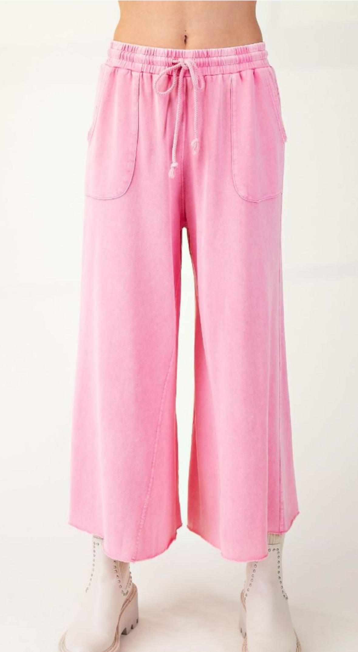 A pair of pink terry knit wide leg pants with adjustable drawstring and side pockets