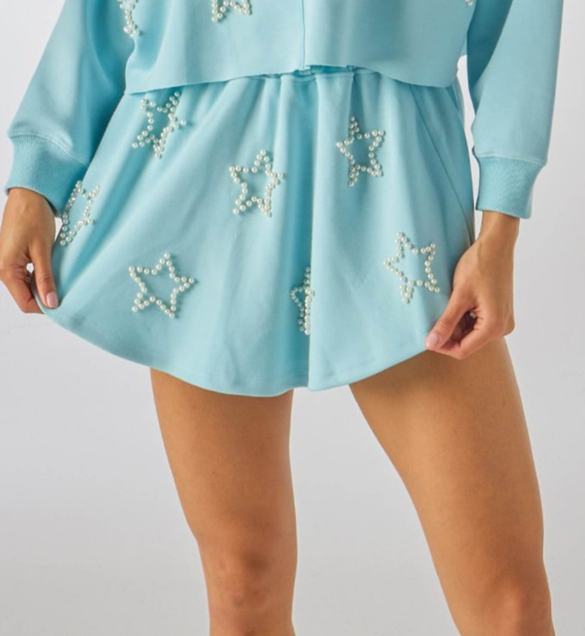 A blue skort with faux pearl outlined star designs, featuring a drawcord elastic waistband.