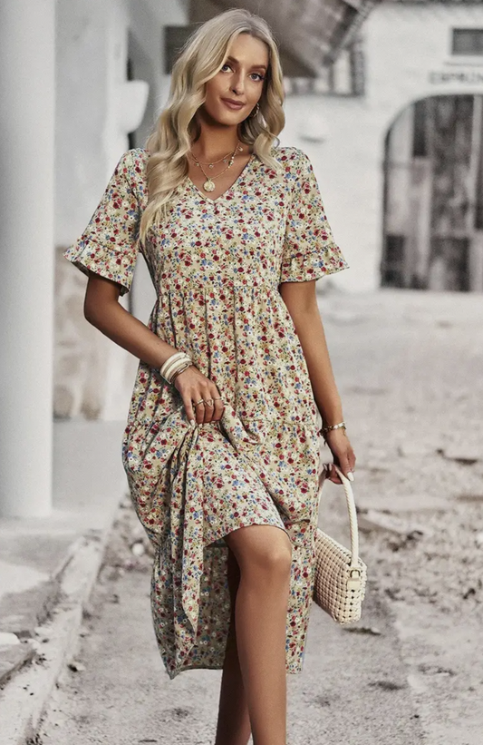 A woman wearing a floral print midi dress with ruffle sleeves, suitable for spring and summer seasons.